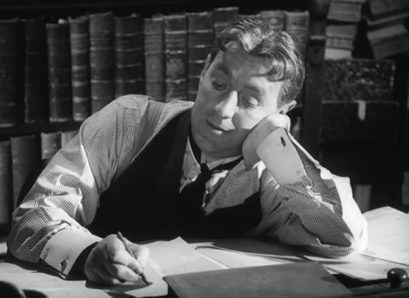 Screenshot of Alec Guinness seating in the office - from The Promoter (1952)