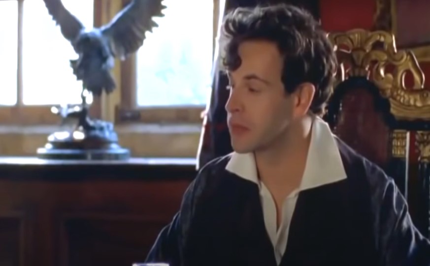 Jonny Lee Miller as Lord Byron sitting at desk