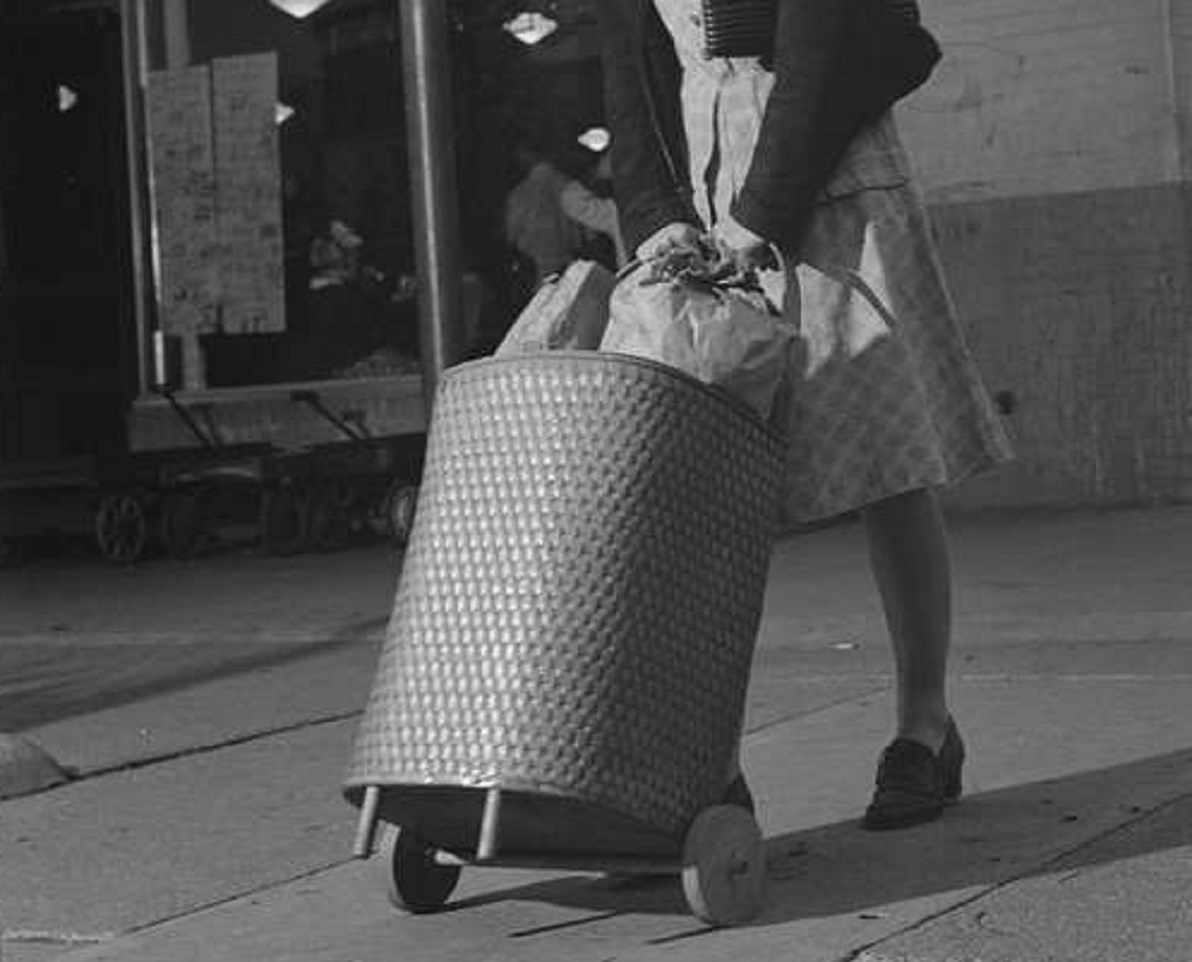 A woman pulling a suitcase on the street - 1942