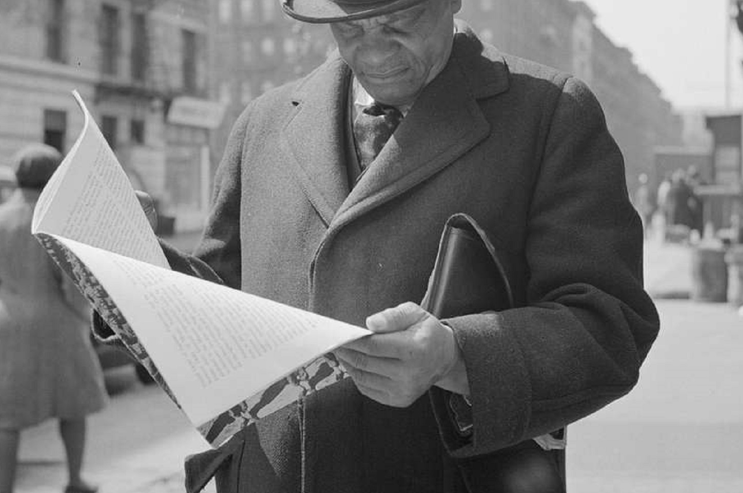 Man reading a newspaper  on the street  - 1943