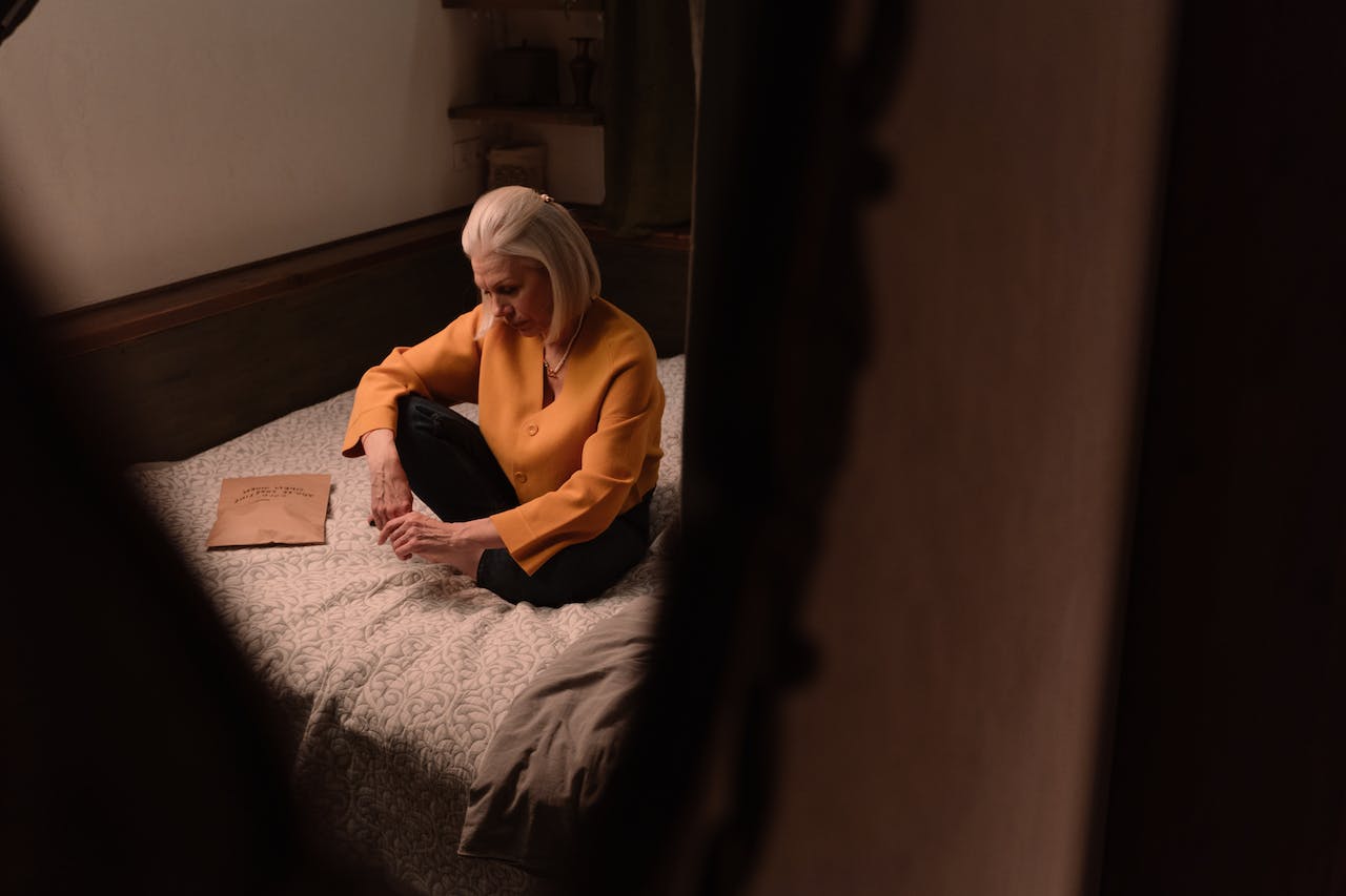 Sad woman seating on the bed