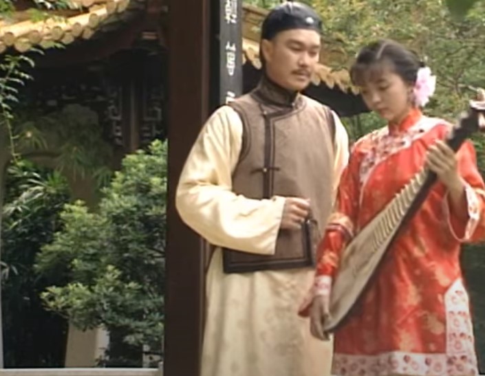 Chen Yulian in Sai Jin Hua in orange clothes playing an instrument for a male