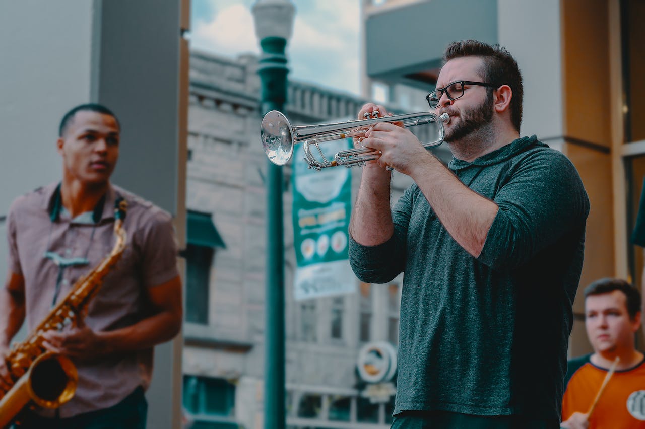 Man playing on trumpet outside.