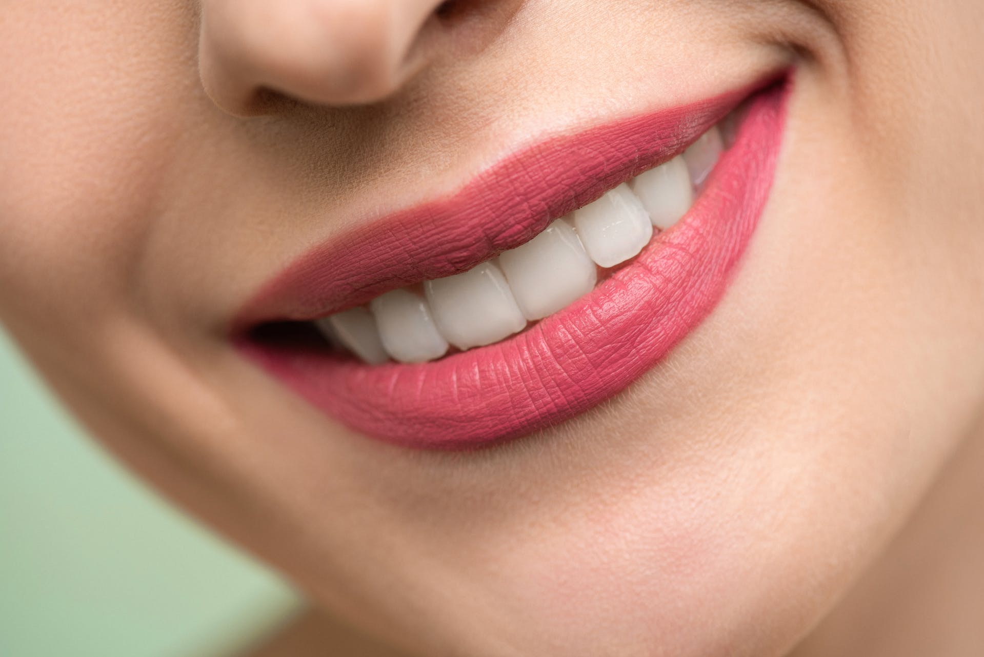 close-up photo of a woman with red lipstick on her lips smiling