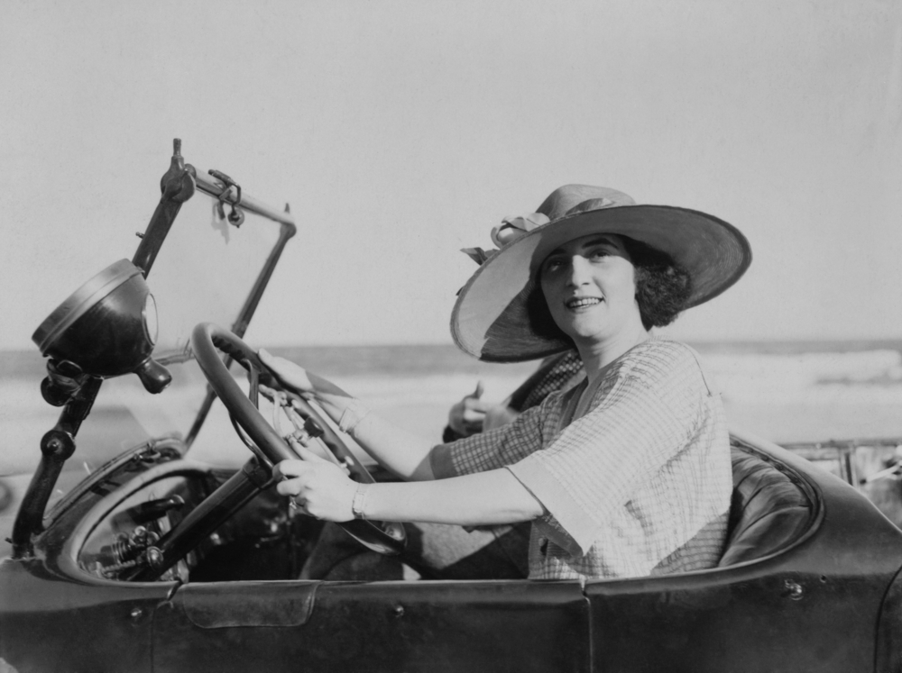 Young woman at steering wheel of automobile
