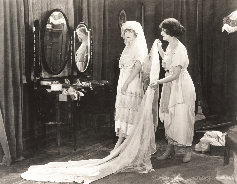 Woman helping bride get dressed