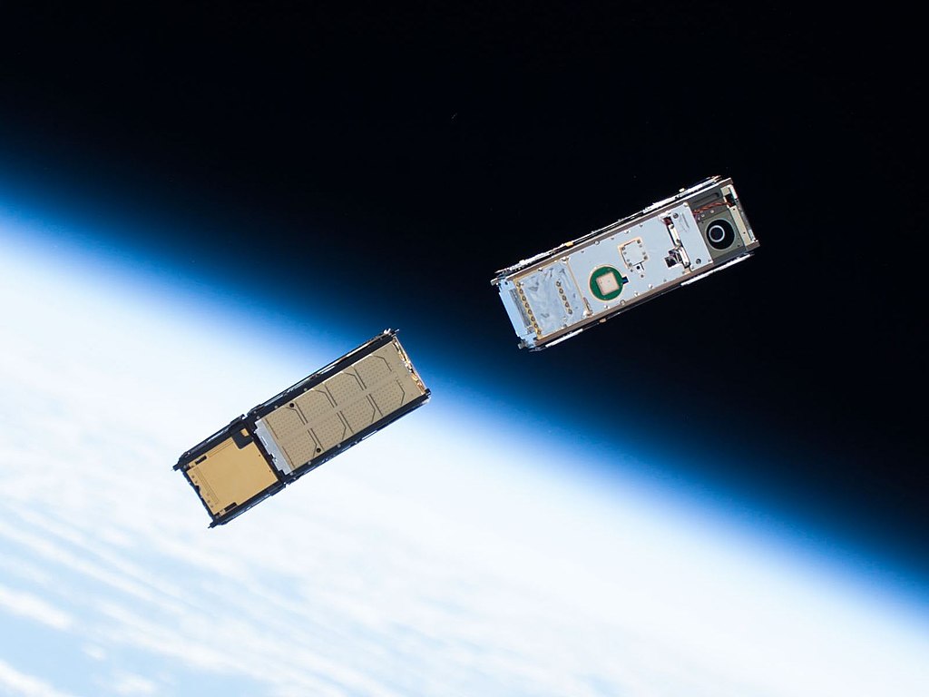 A pair of CubeSats, with the Earth's limb in the background