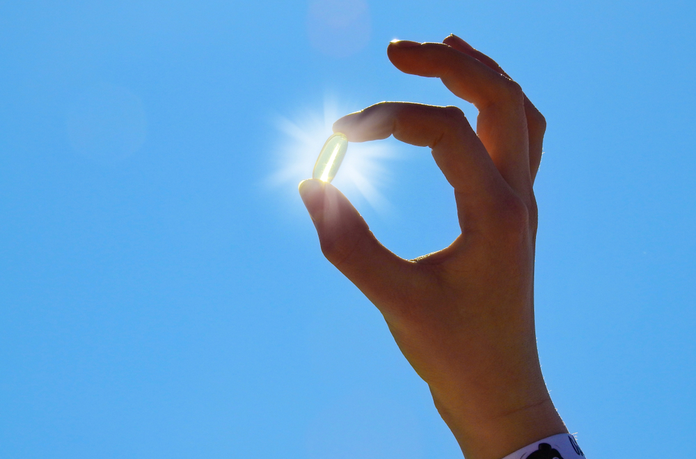 Young Woman  holding Vitamin D Capsule