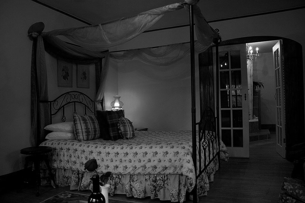Photo of a Vintage bed, vase of flowers in front.