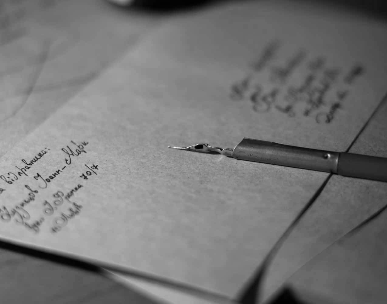 brown envelop on table, fountain pen on top