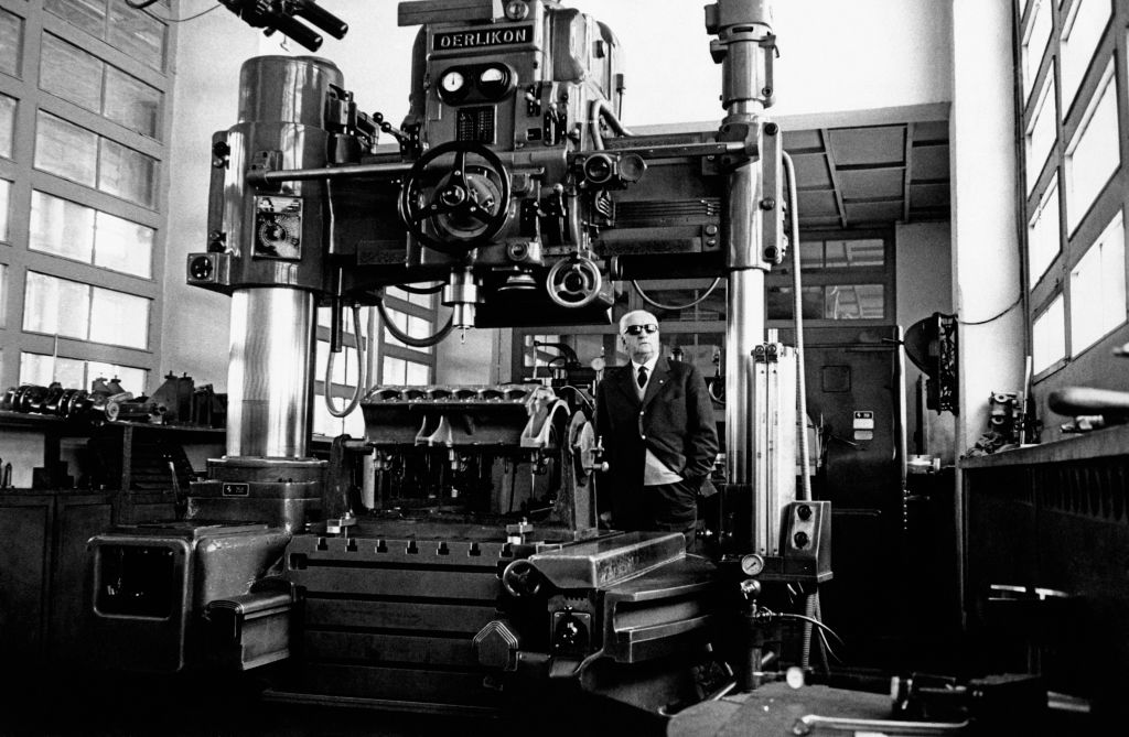 Enzo Ferrari posing beside a machinary