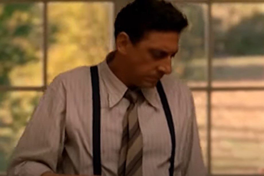 Sergio Castellitto as Enzo Ferrari in suit applying