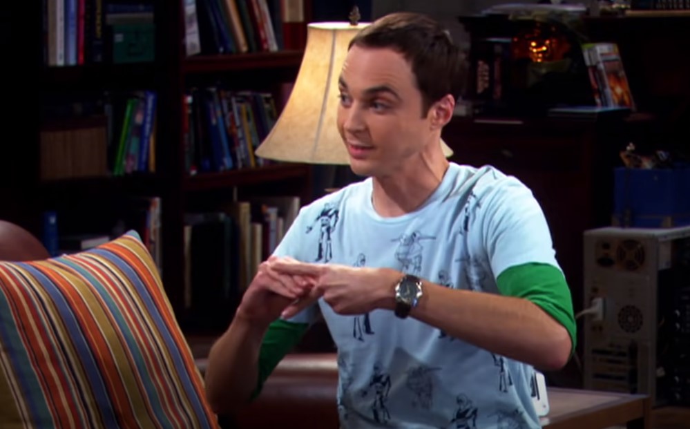 Sheldon in white t-shirt sitting on his spot 