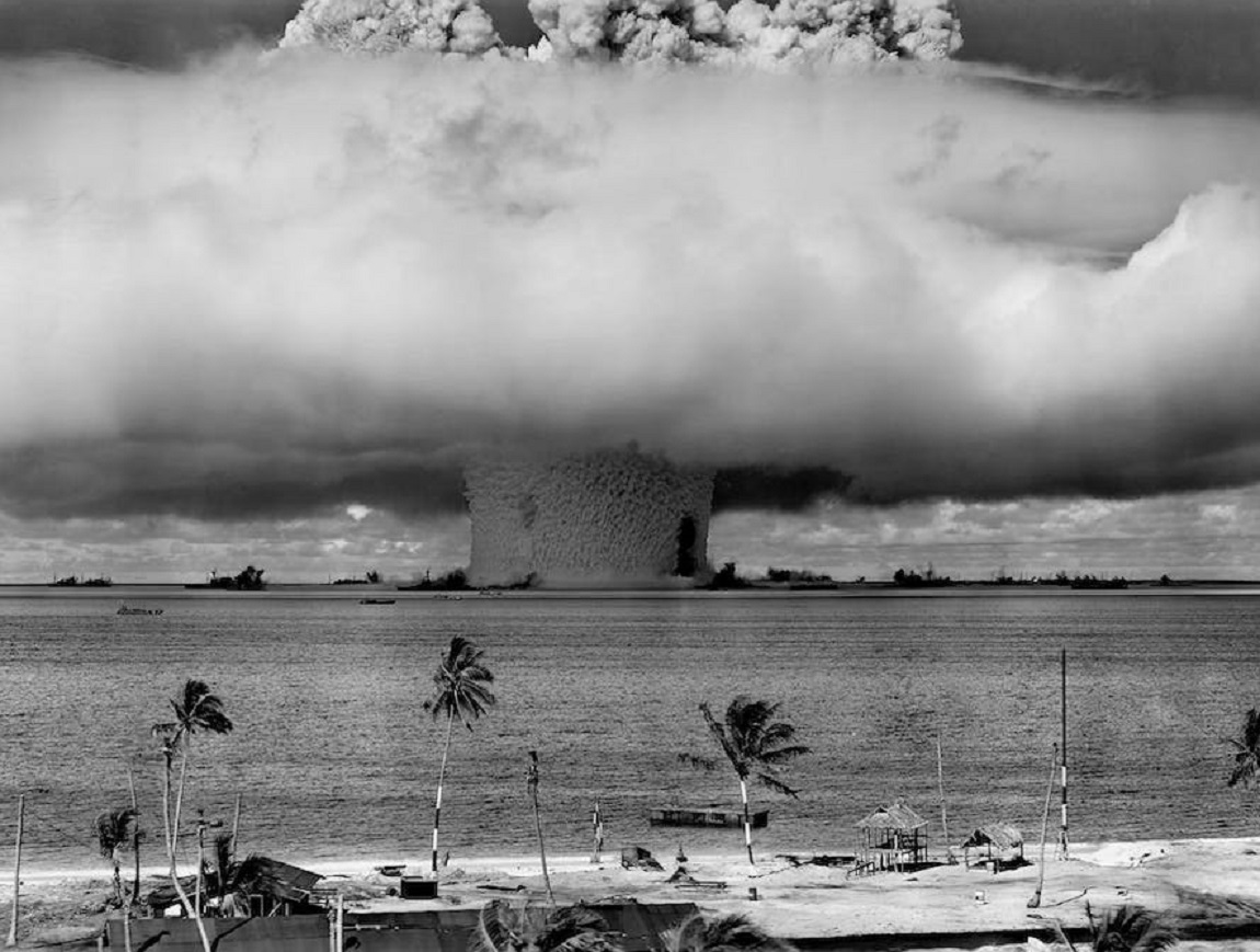 Grayscale photo of explosion on the beach.