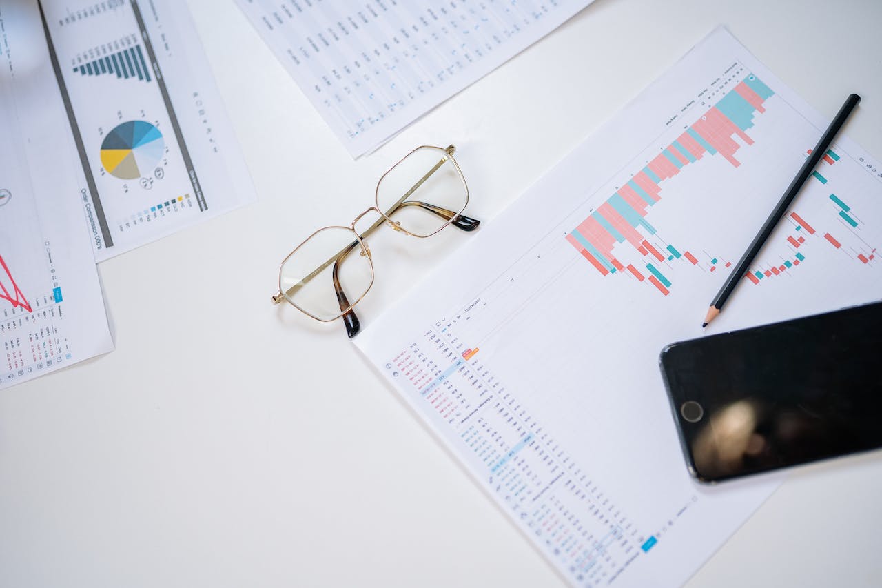 Eyeglasses, chart and pencil on office desk.