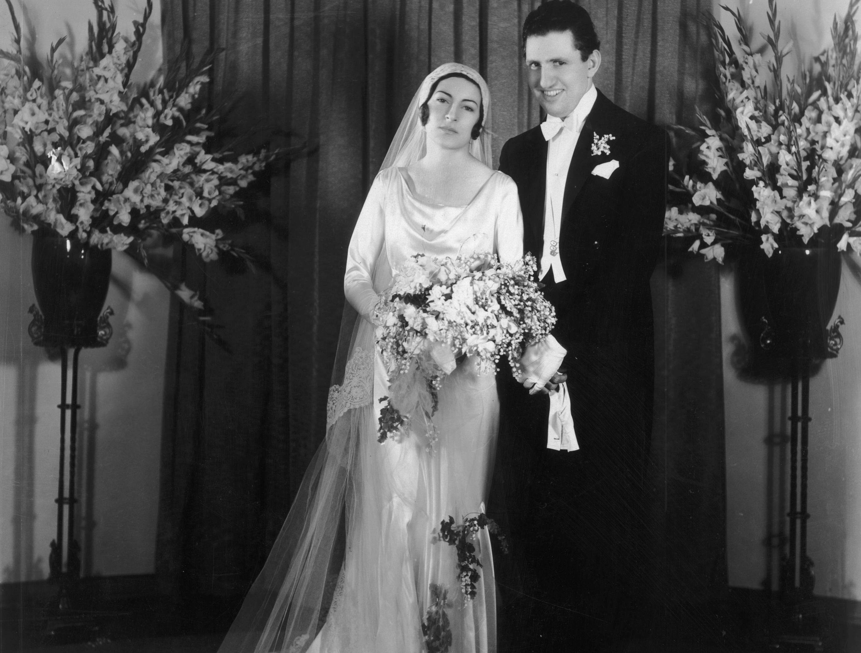 Full-length portrait of American film producer David O. Selznick (1902 - 1965) and his first wife, Irene Mayer, on their wedding day