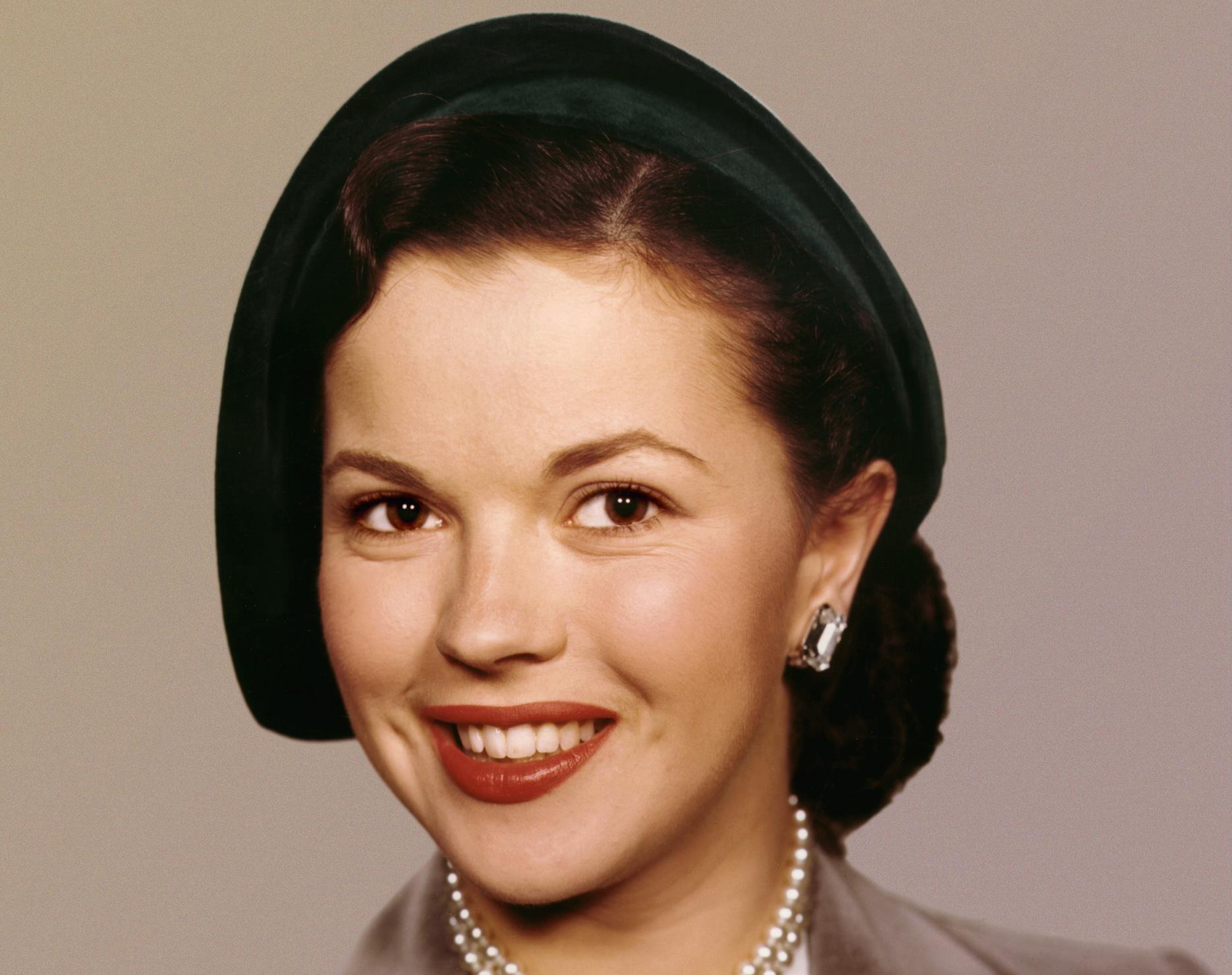Shirley Temple in brown coat and green hat