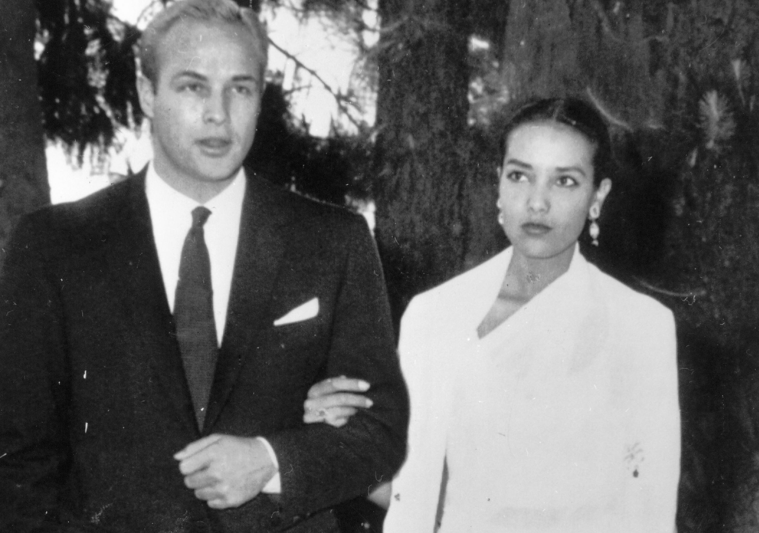 Marlon Brando, Anna Kashfi in formal wear looking at the camera