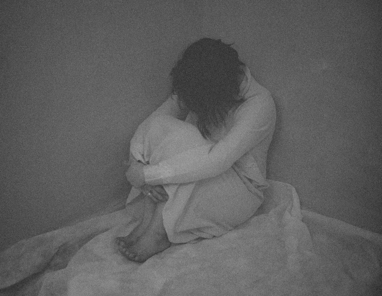 Alone sad woman seating in dark room