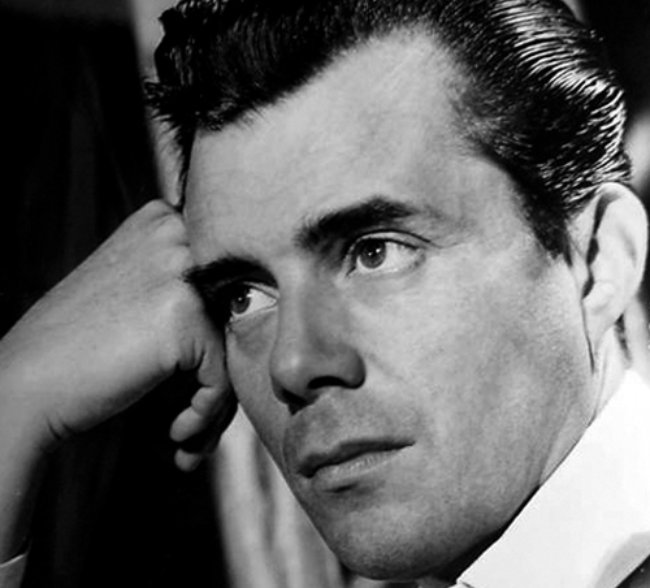 Dirk Bogarde posing for a photo