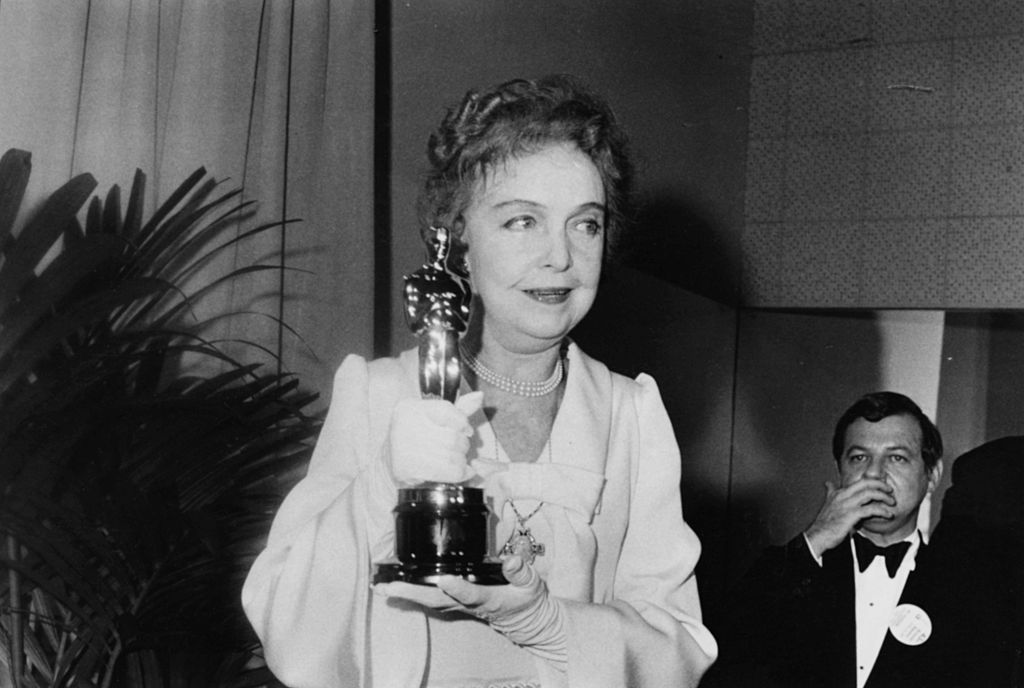Actress Lillian Gish holding her Honorary Oscar in white dress