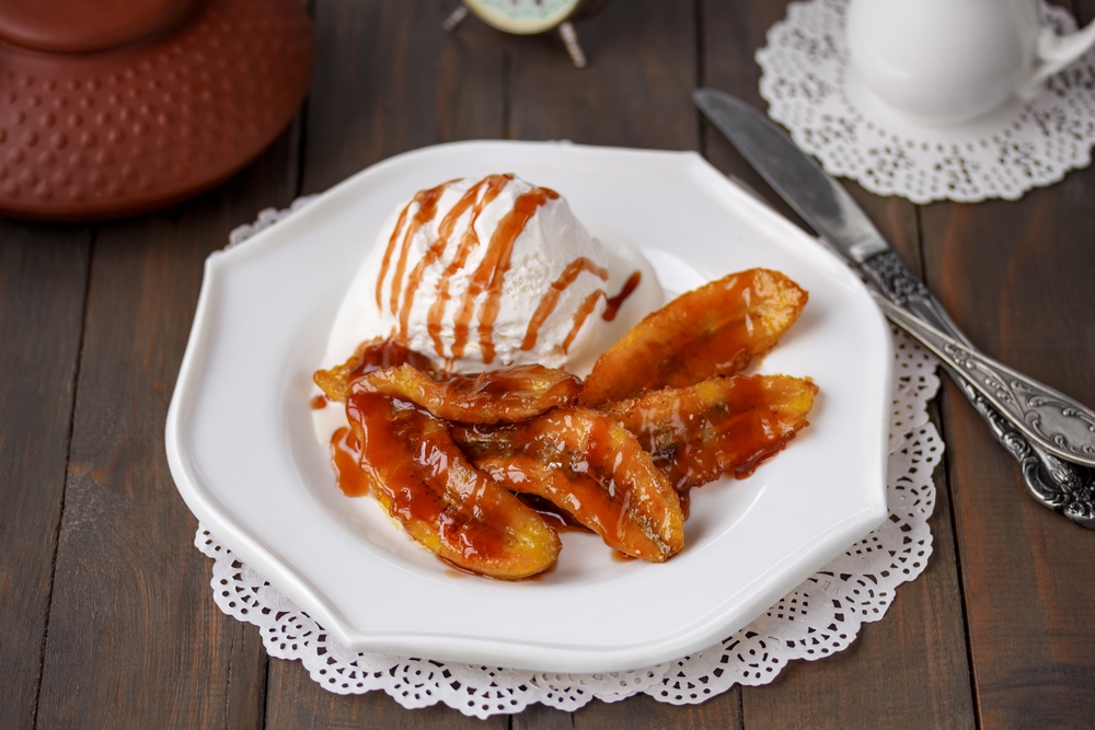 Bananas Foster. A portion of sweet caramelized sliced bananas and a flambéed rum sauce served with scoop of vanilla ice cream