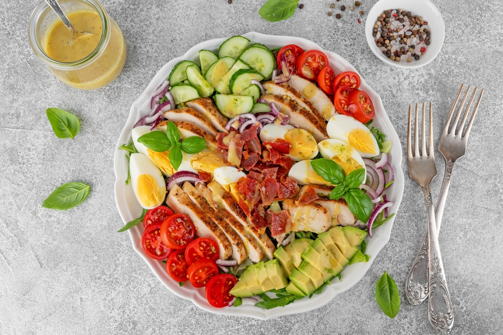 Healthy cobb salad and green leaves on a plate.
