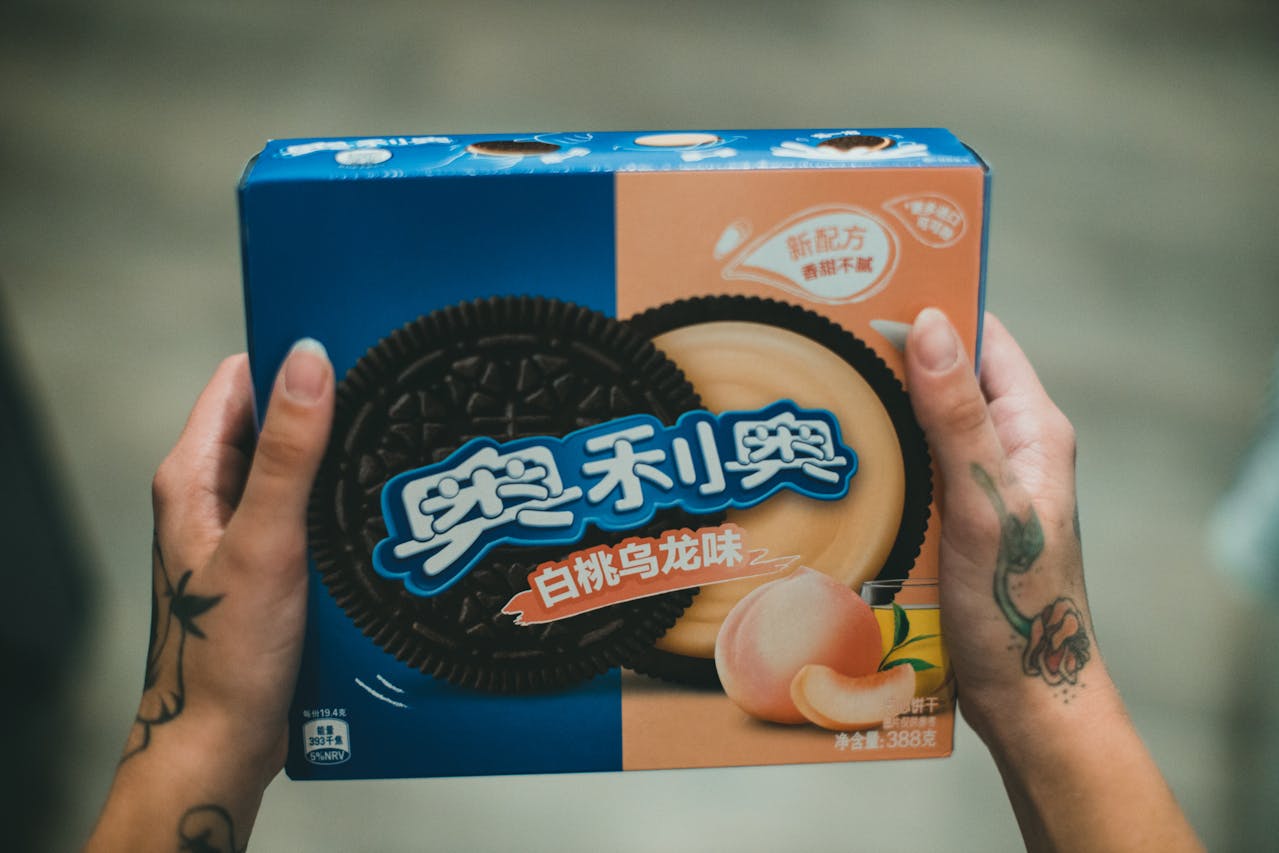 Person holding a box with White Peach Oolang Tea Oreos