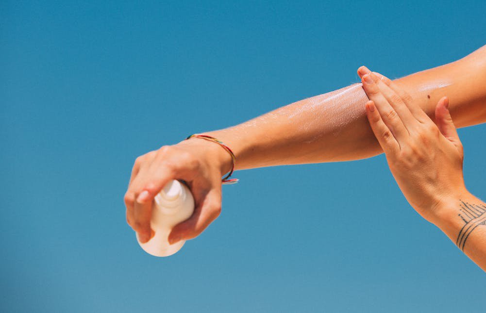 A woman applying sunscreen
