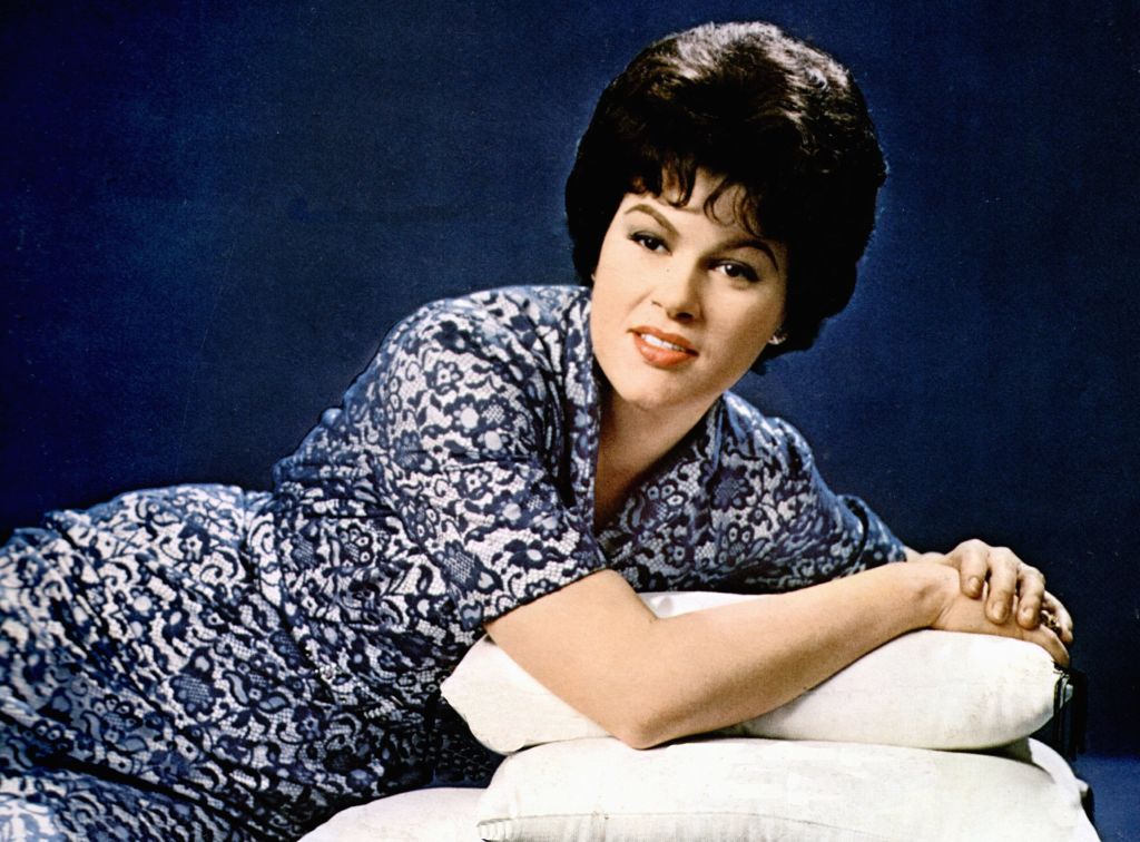 Patsy Cline wearing a blue and white dress