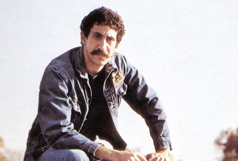 Portrait Photo of Jim Croce sitting on guitar case