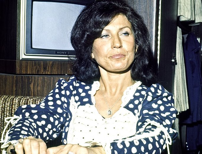 Loretta Lynn wearing a blue dress with white dots