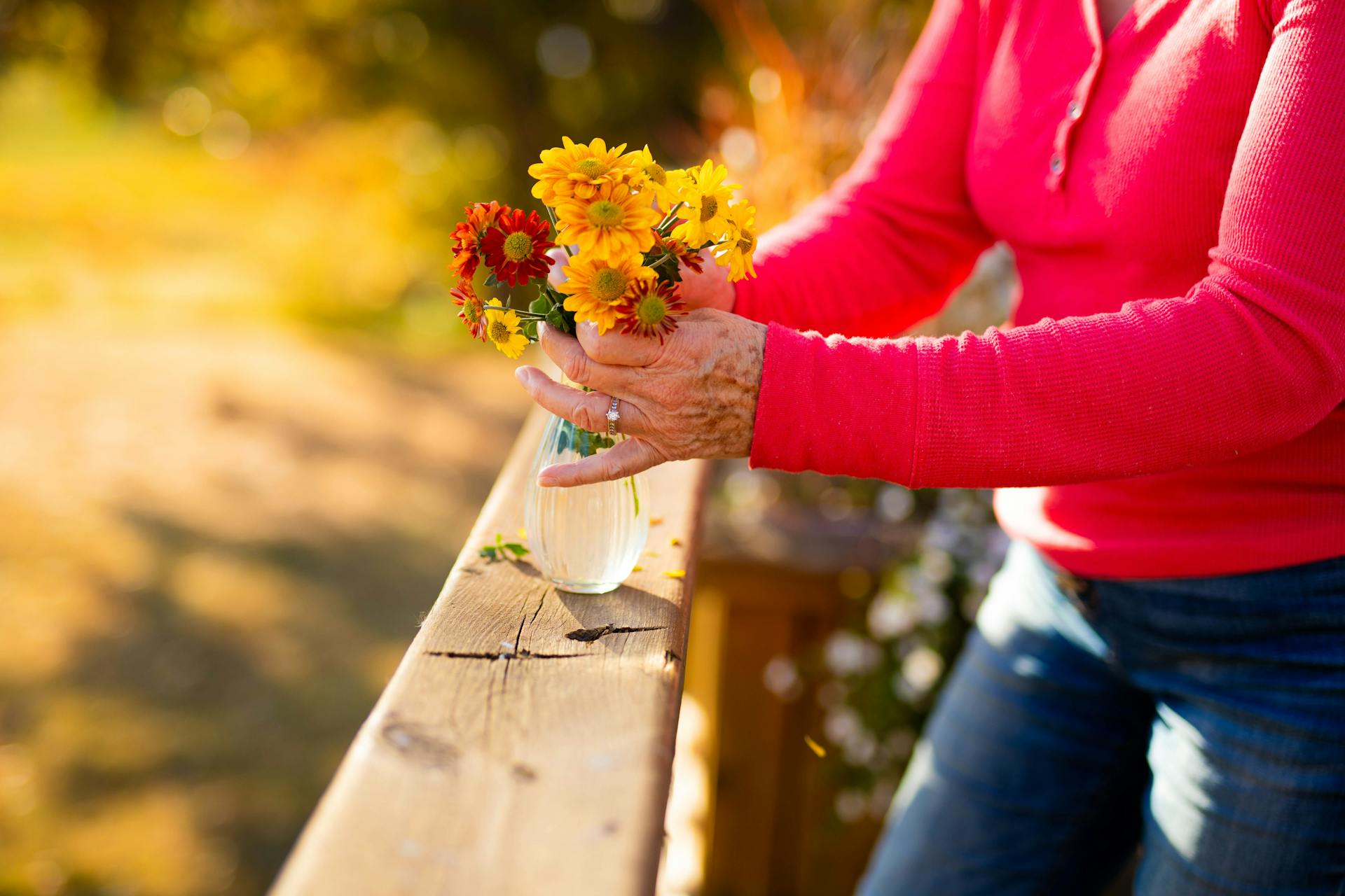 Senior lonely Woman Arranging Flowers Outdoors in Autumn