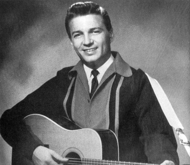 Waylon Jennings posing with a guitar