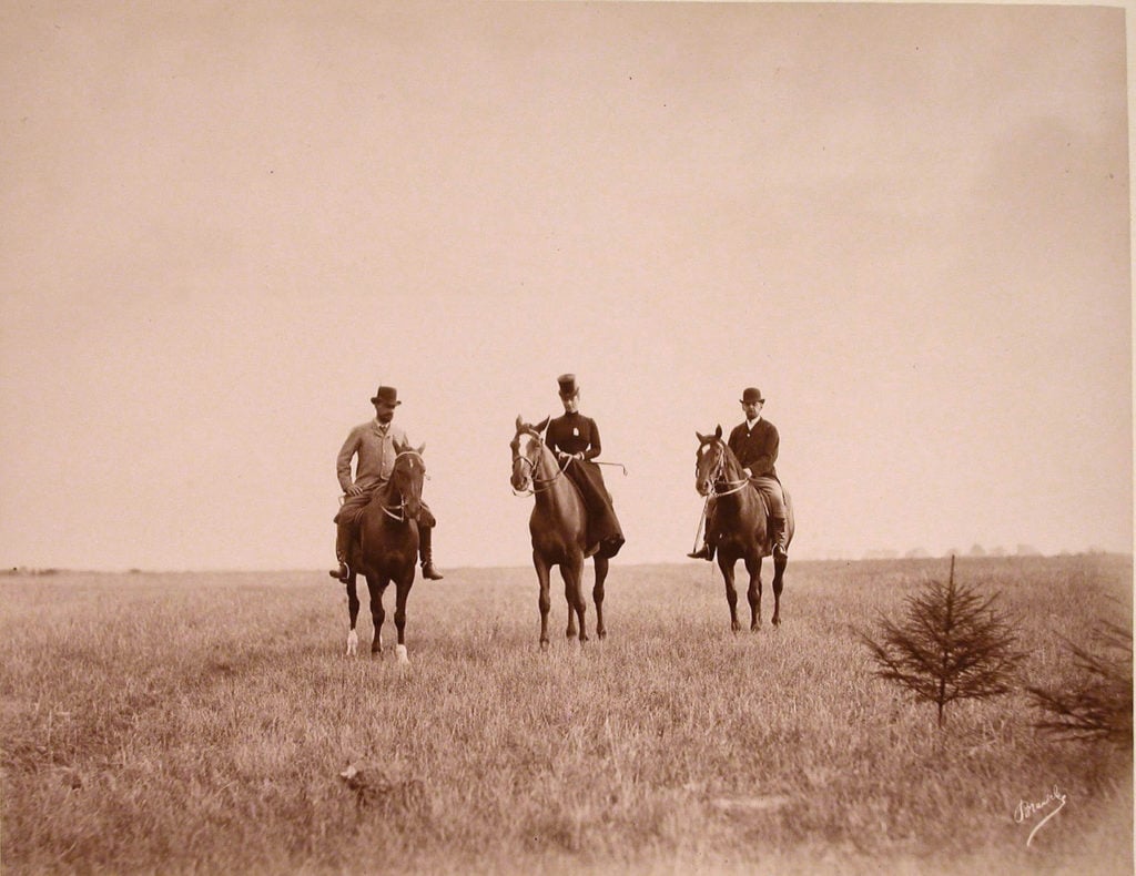 Woman and two man riding on horses