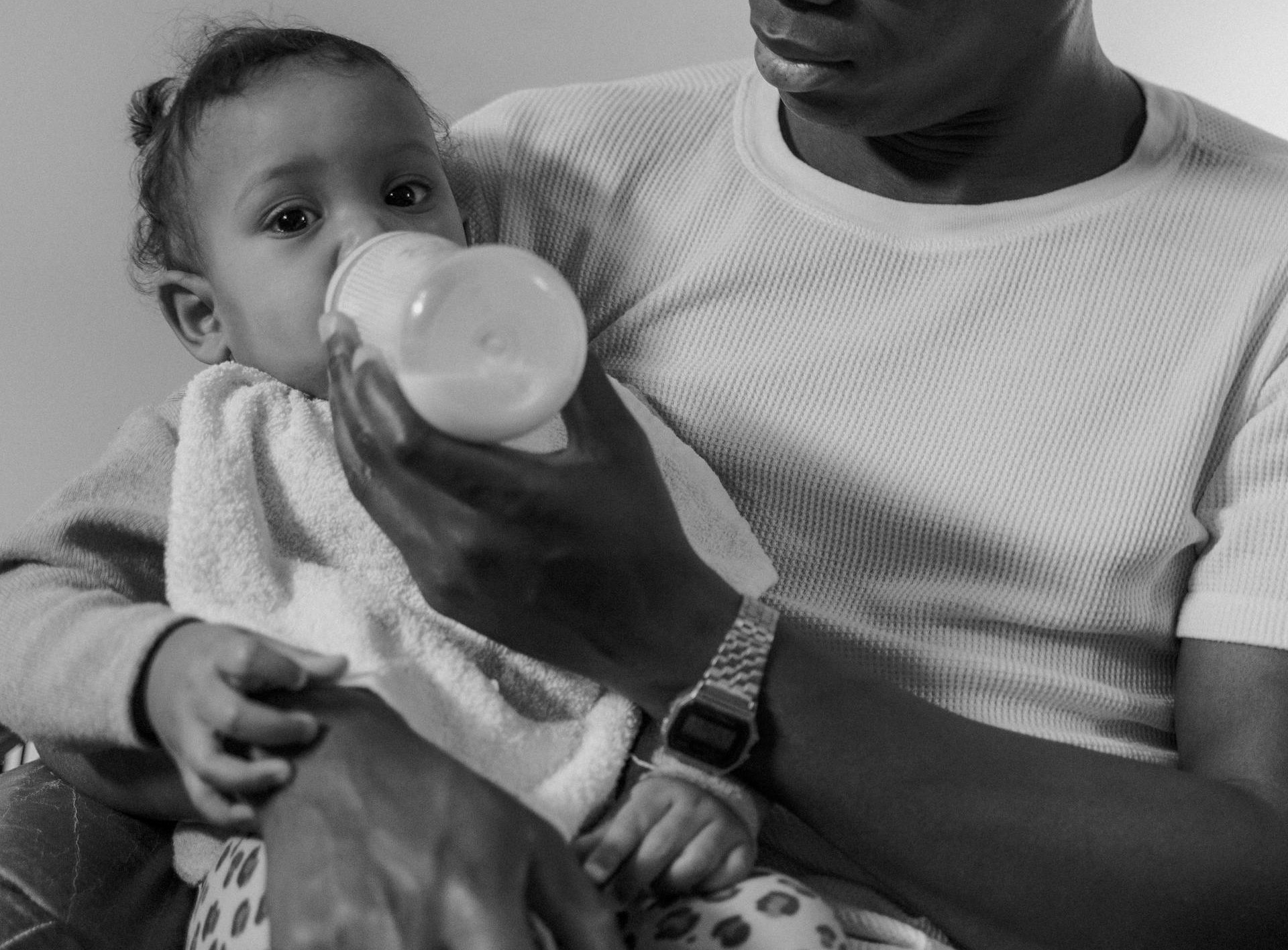 Photo of Man Feeding a Toddler