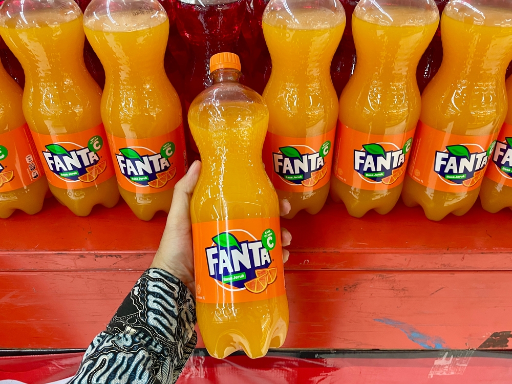 Hand holding orange Fanta