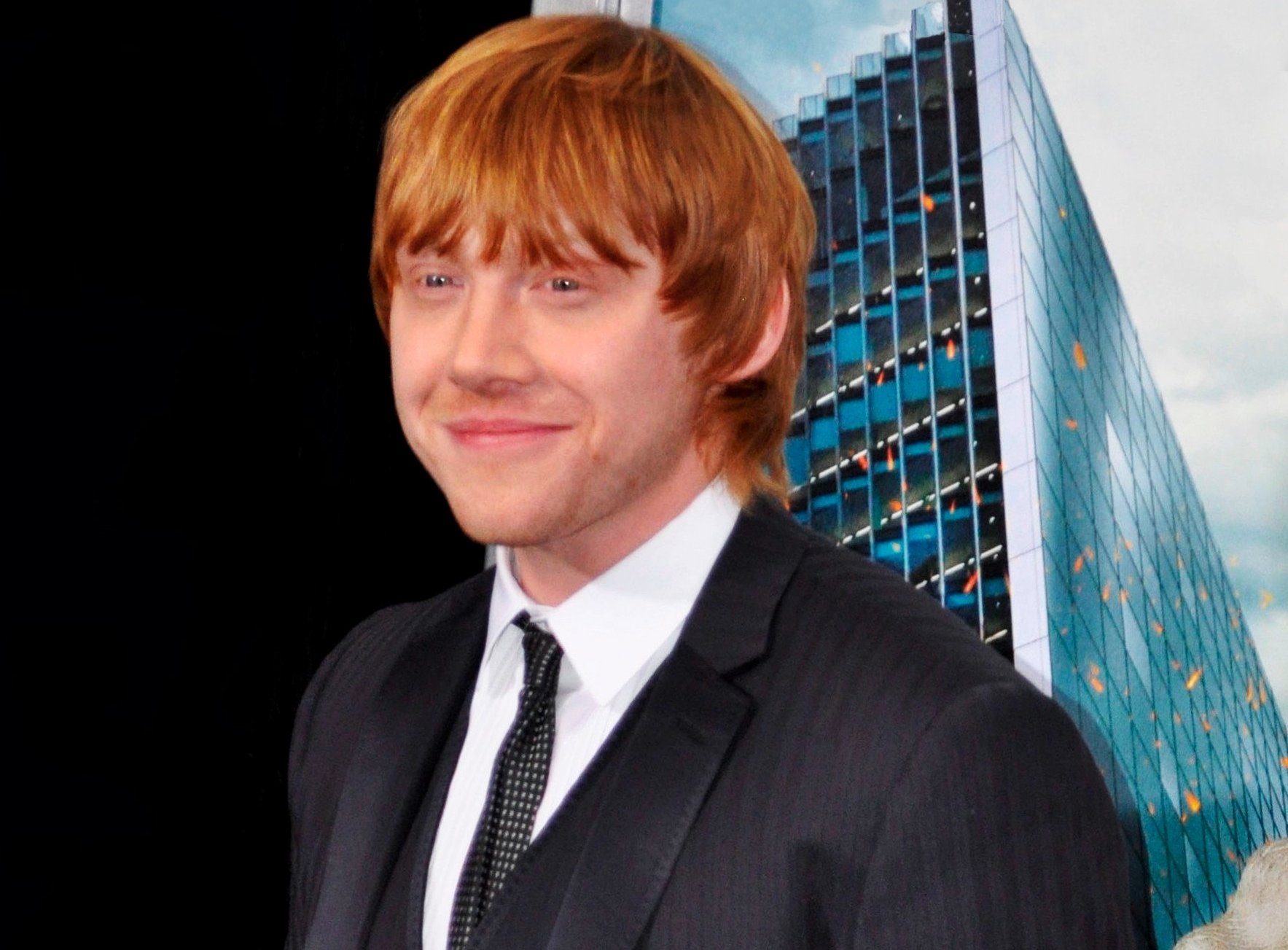 Rupert Grint wearing a black suit