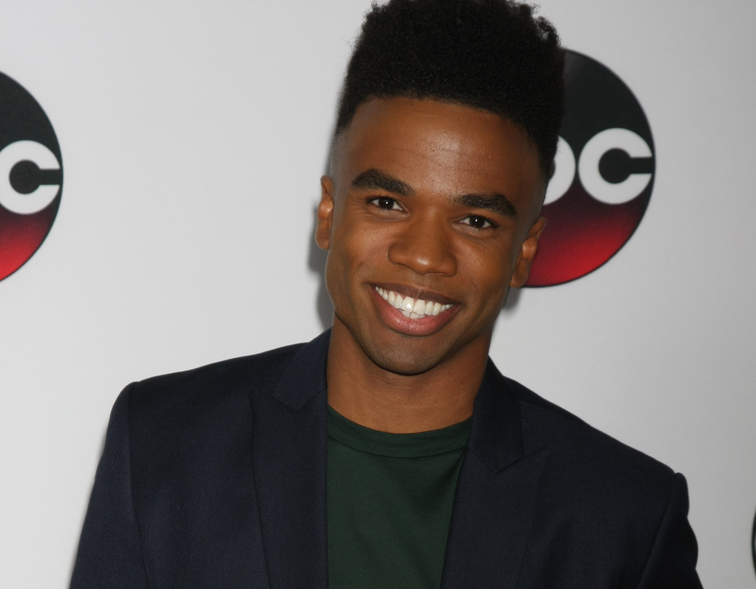 Luke Youngblood in a green shirt and a black jacket