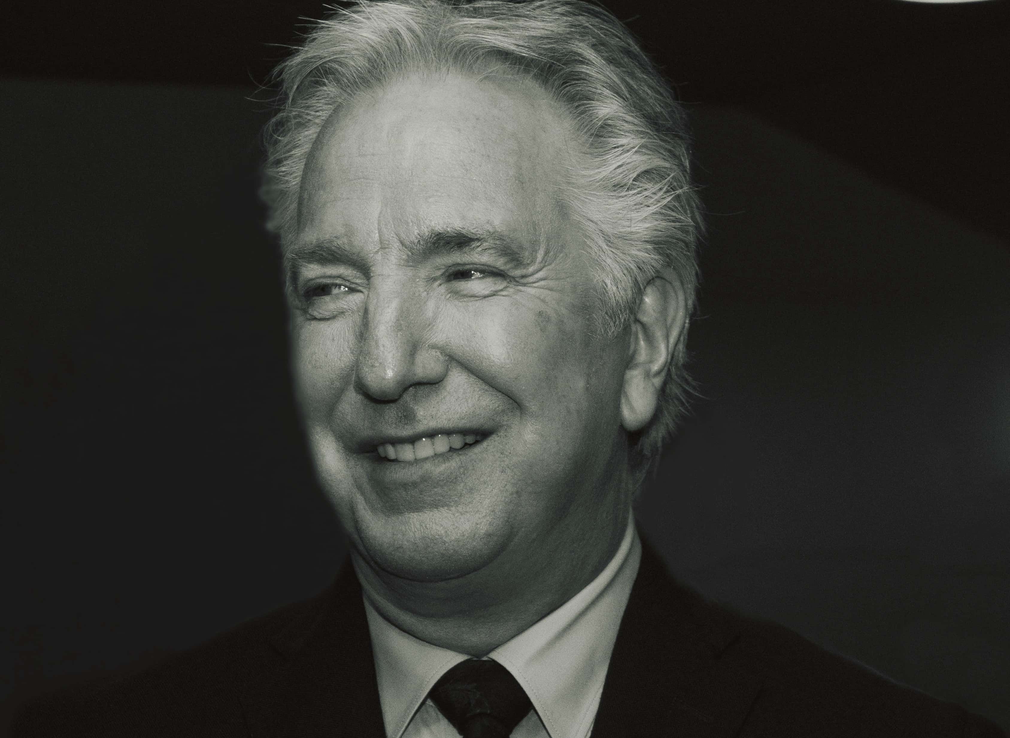 Actor Alan Rickman wearing a black suit