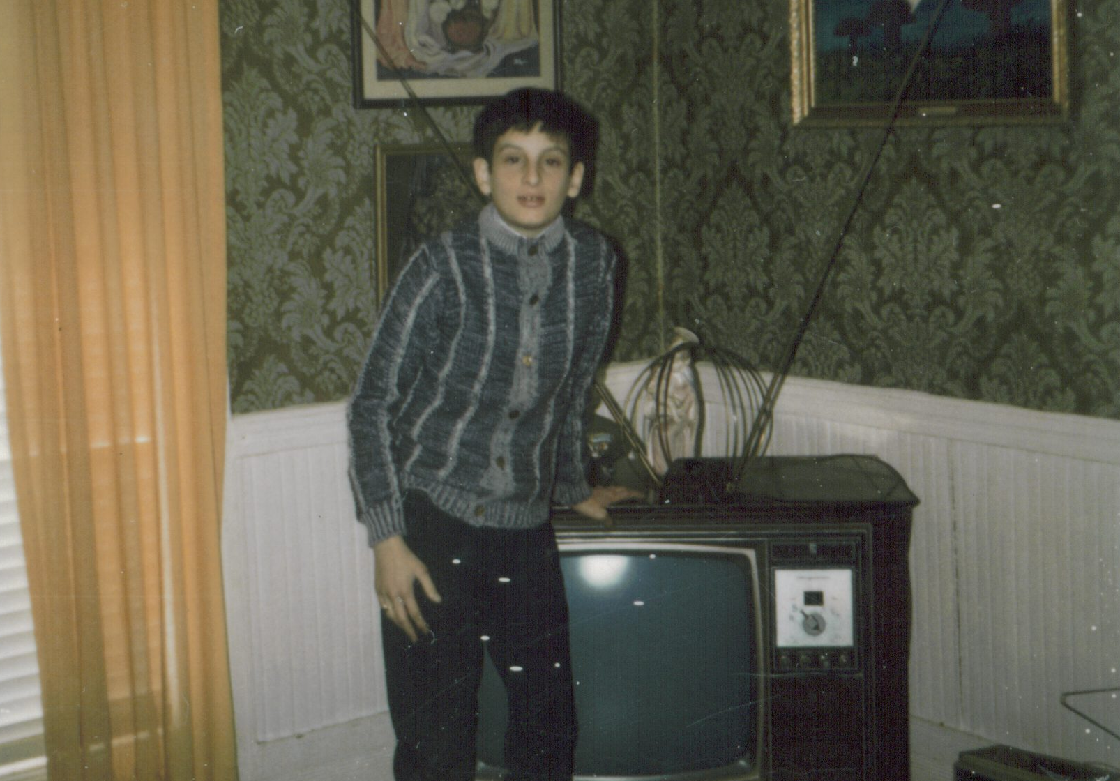 A kid next to a TV in the 1970s