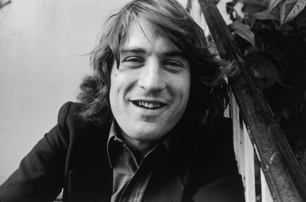 Robert De Niro with shaggy hair, smiling