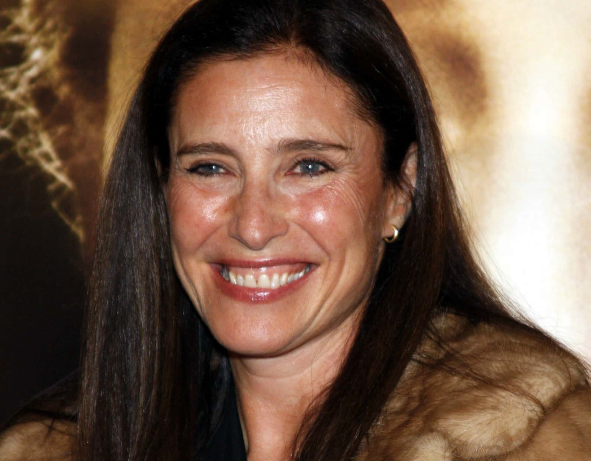 Mimi Rogers wearing a fur coat