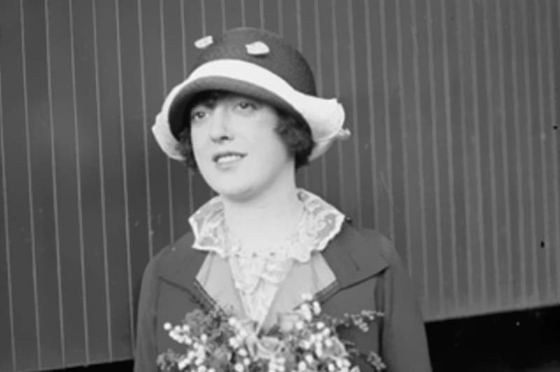 Informal half-length photo portrait of Mabel Normand in jacket and a hat