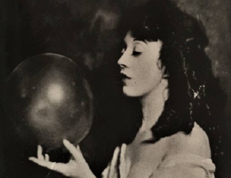 Mabel Normand in white shirt holding a ball
