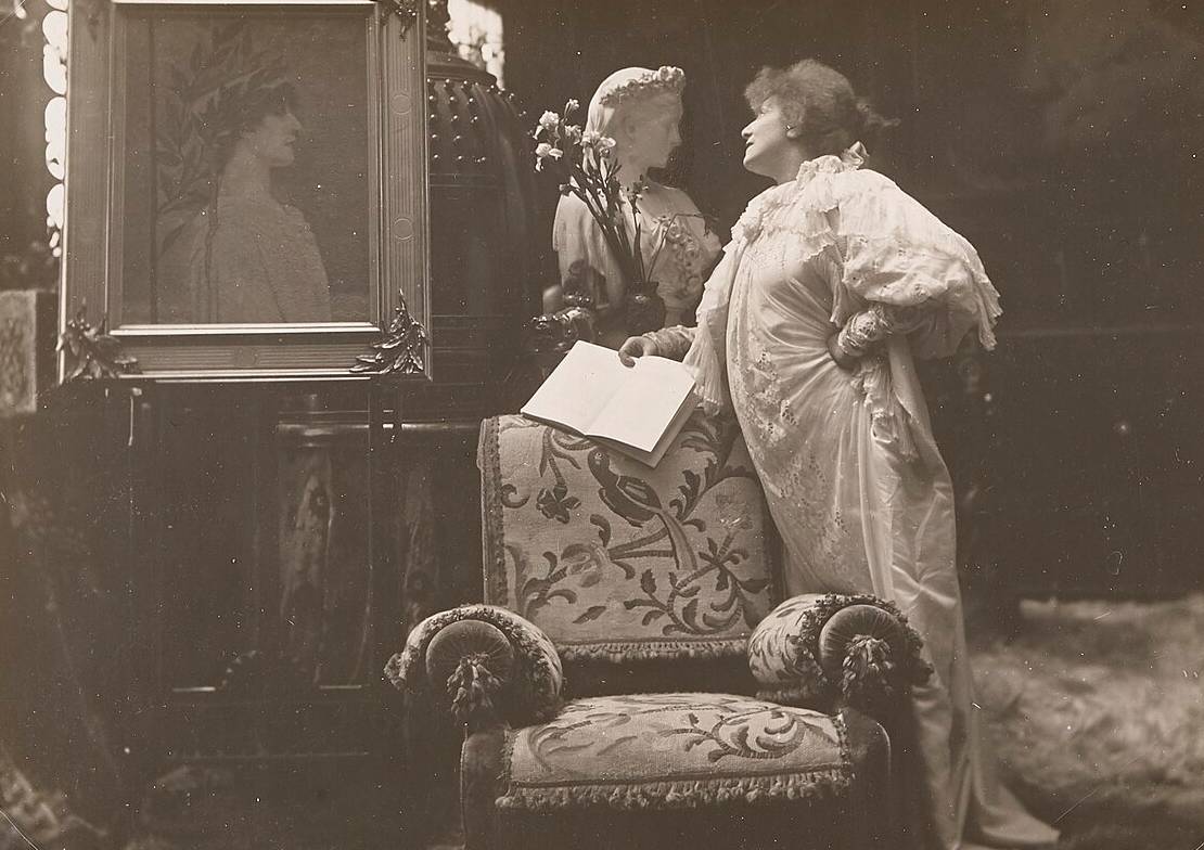 Sarah Bernhardt standing with a book in her hand