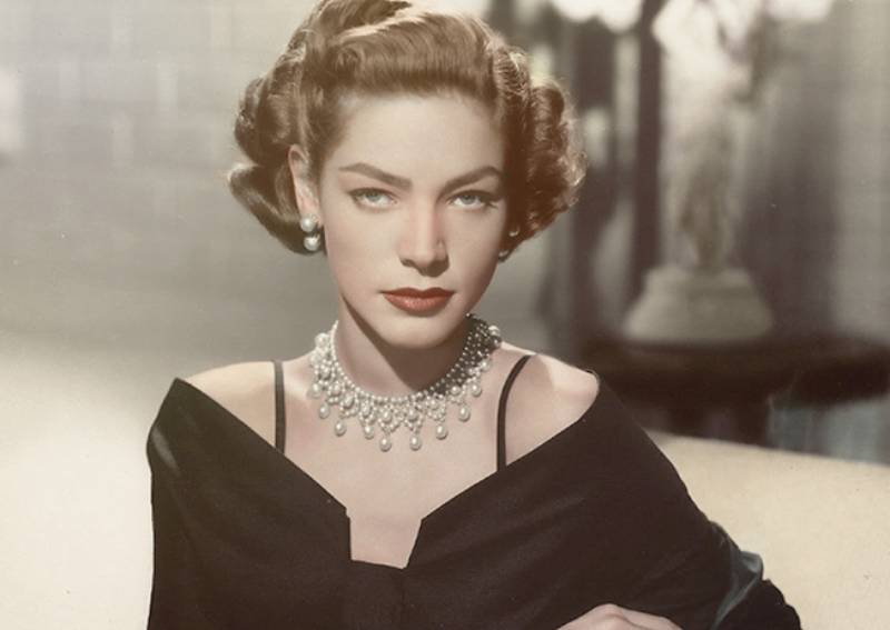 Lauren Bacall in black dress and pearl necklace