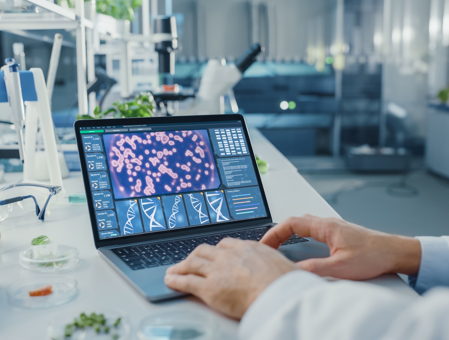 Male Scientist Working on a Laptop Computer with Display Showing Gene Editing Interface.