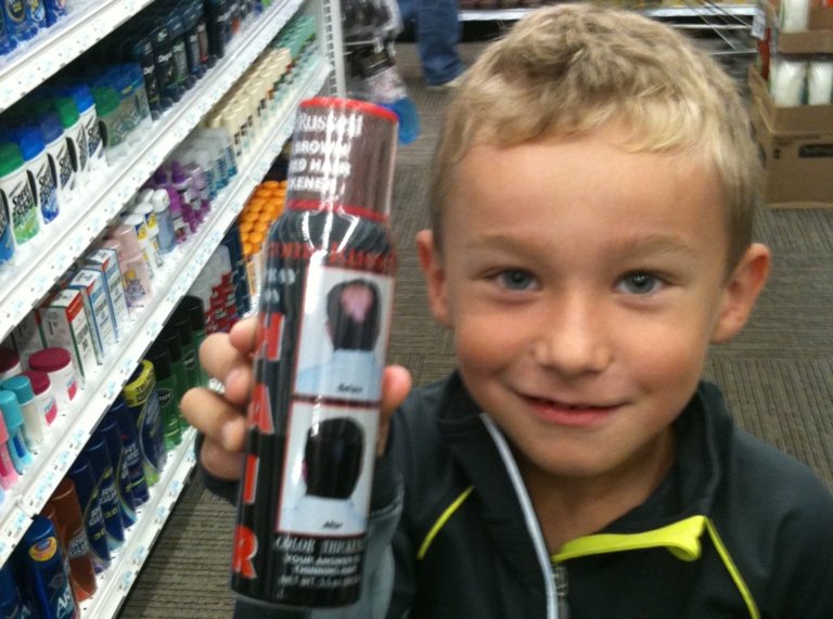 Kid holding a spray-on hair product in a store