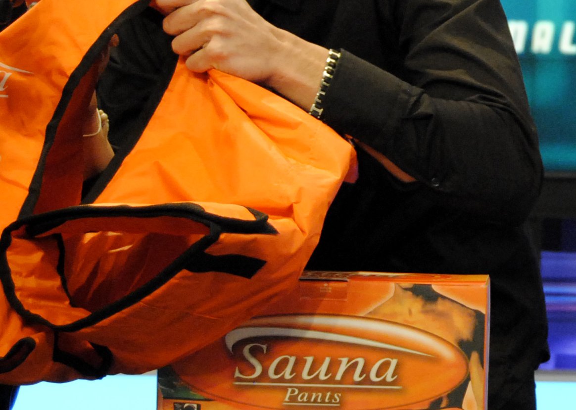 Person holding and showing sauna pants